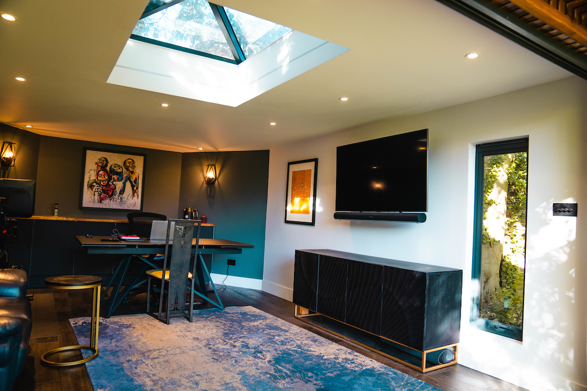 Inside of a room with skylight and large TV on the wall