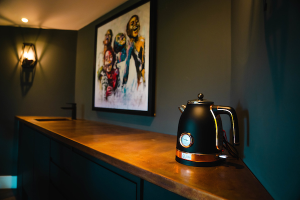 A room with black walls and a black kettle