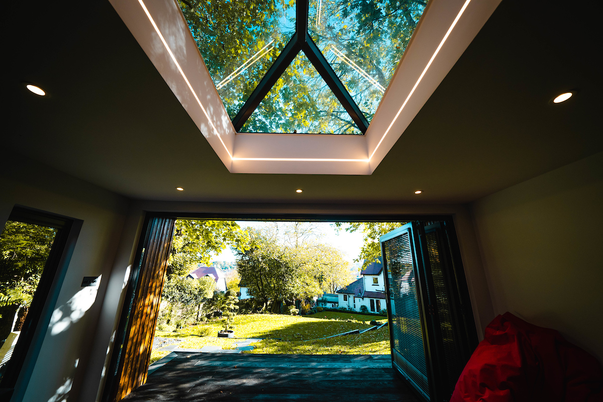 Inside of a room built on a garden with a skylight