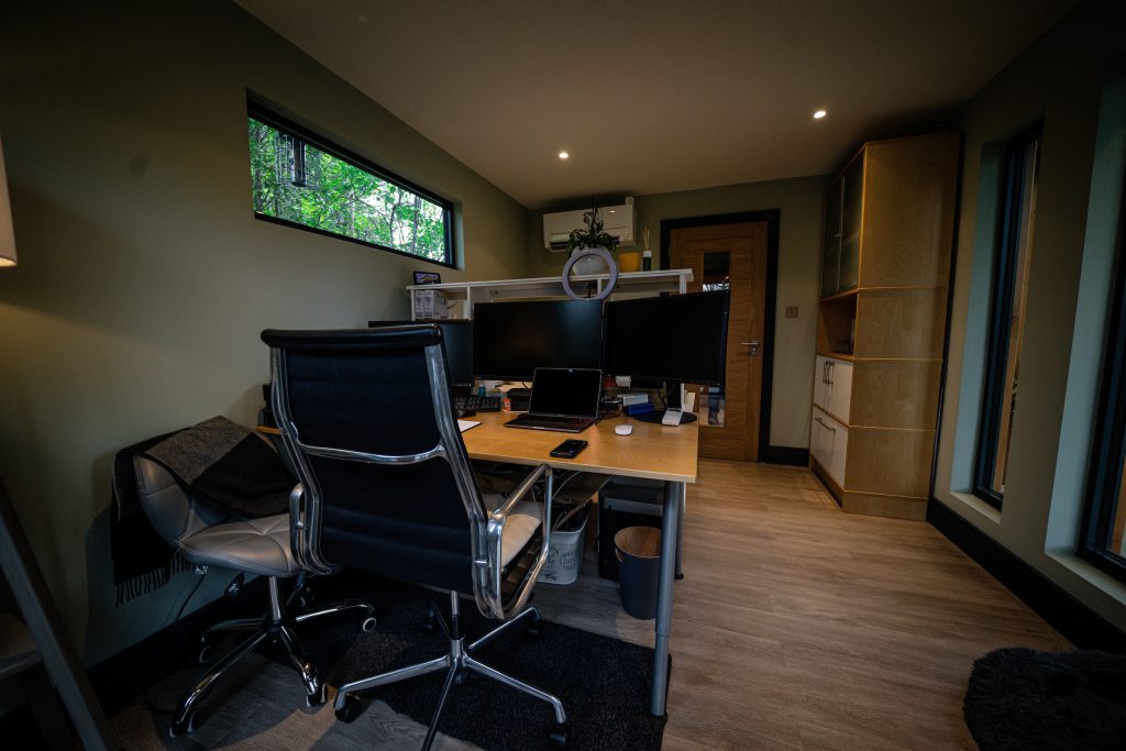 Black working chair and wooden desk with many screens