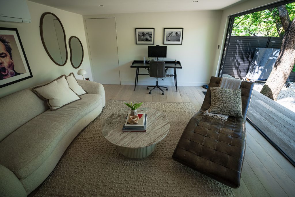 Beige sofa and a working desk in a large garden room