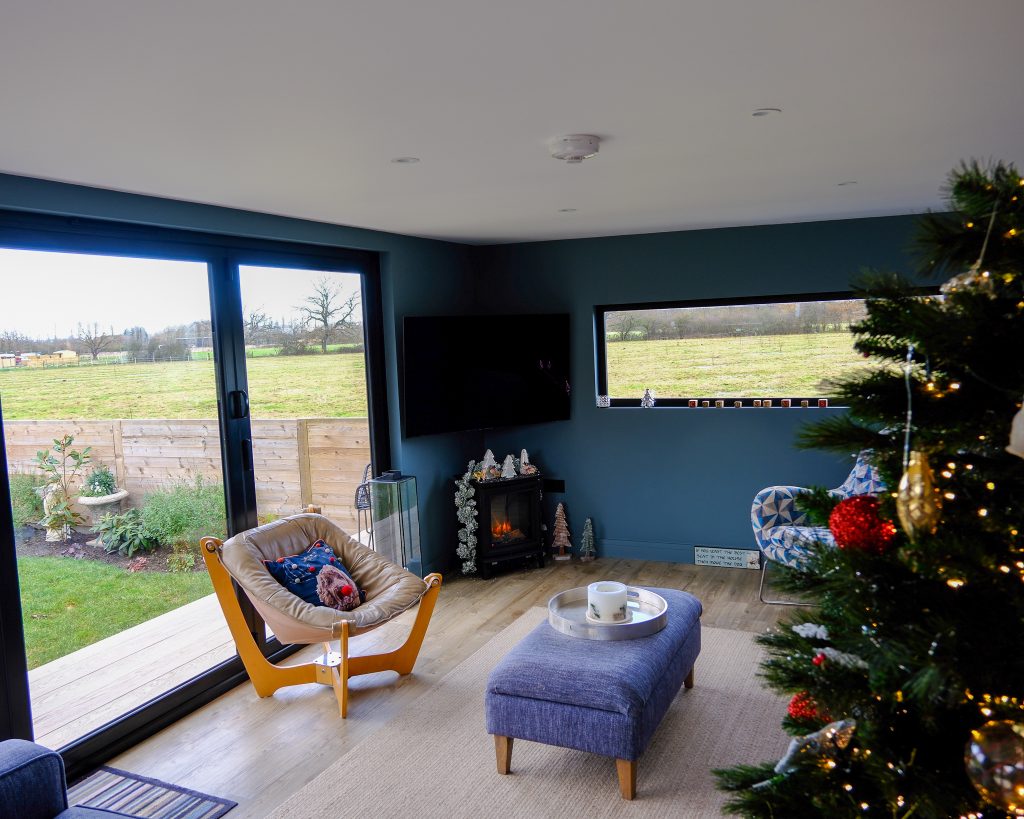 Blue ottoman next to a Christmas tree in a garden room