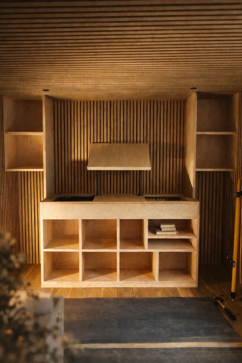 Timber slat feature wall with floating oak shelves and an integrated media unit