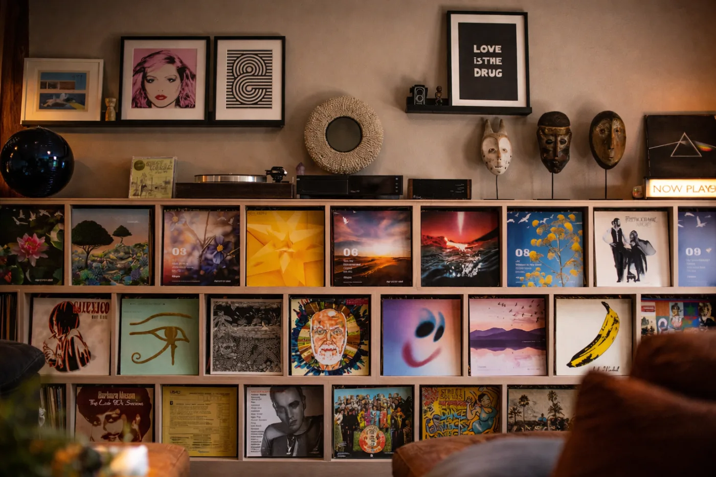 Display and feature wall with open shelving holding records, books and framed artwork